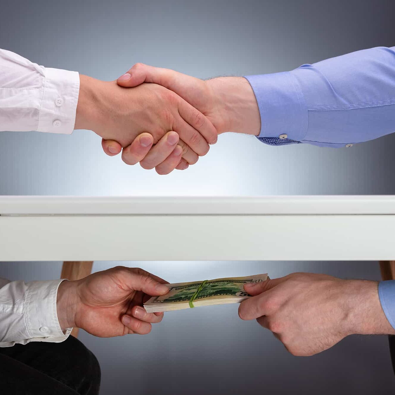 Businessmen Shaking Hands After The Business Deal Receiving A Bribe Money Under The Table