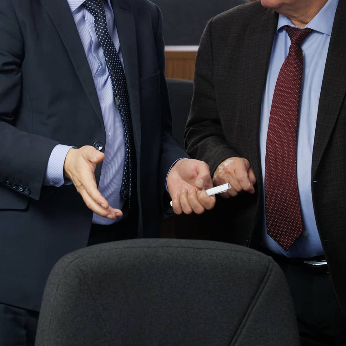 Two politicians or businessmen are talking to each other before the start of a meeting or conference. Discussion of the pressing issues of our time. Preparing for a decision. Without a face.