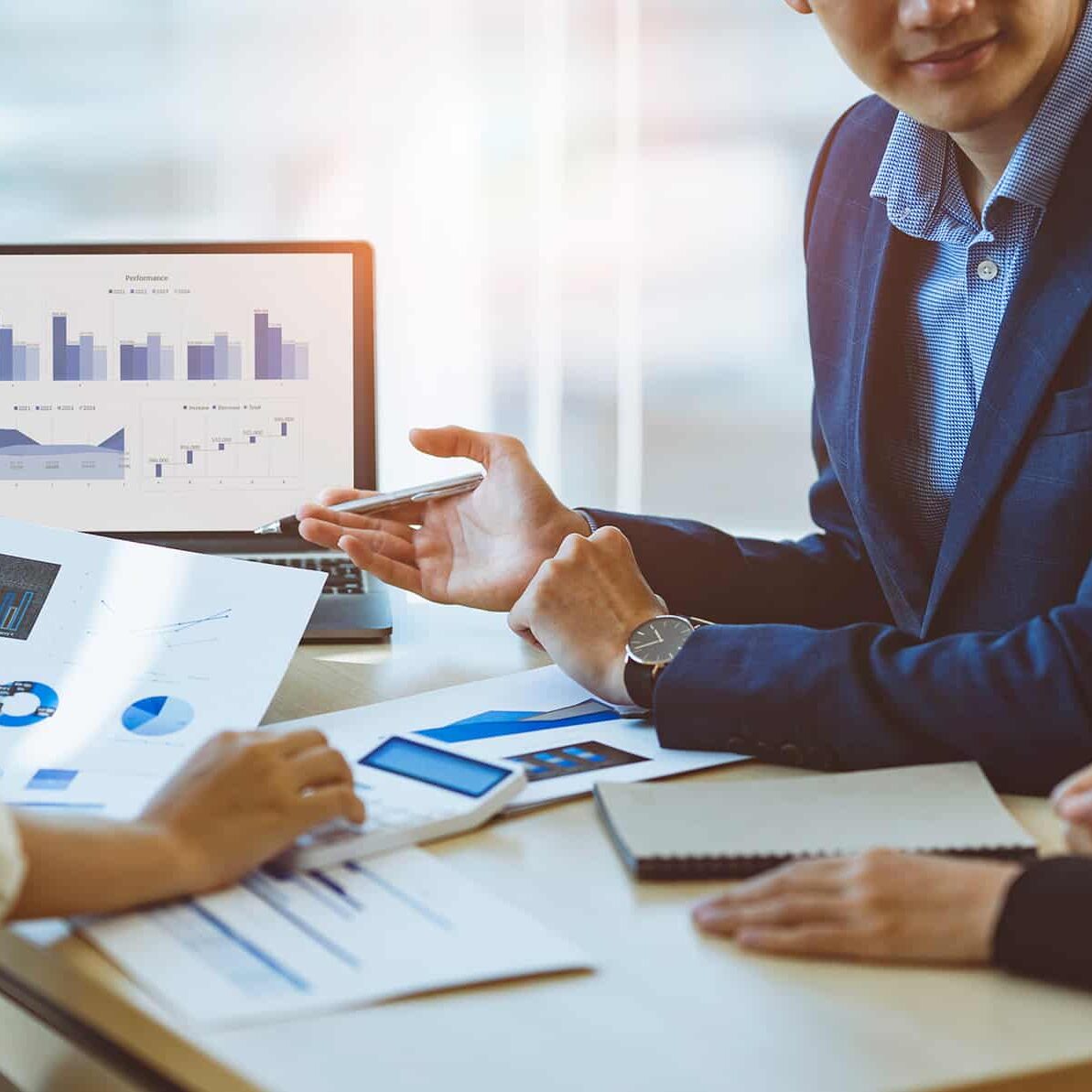 A male business consultant describes a marketing plan to set business strategies for women business owners with using calculator. business planning and business researching concept.