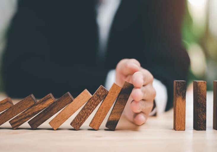 protection and risk management, Financial risk management ,Business Investment Feasibility Assessment, protection of business interests, Human hands blocking wooden sticks