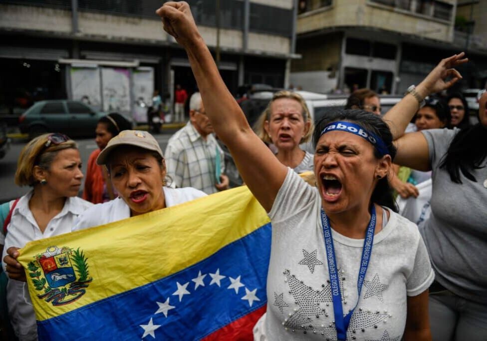Nurses shout slogans demanding fair and higher wages during a protest for the lack of medicines, medical supplies and poor conditions in hospitals, in front of the headquarters of the Venezuelan Institute of Social Security (IVSS) in Caracas, on August 14, 2019. - Many nurses look for alternative jobs or small business to get money to face daily inflation. (Photo by Federico PARRA / AFP)        (Photo credit should read FEDERICO PARRA/AFP/Getty Images)