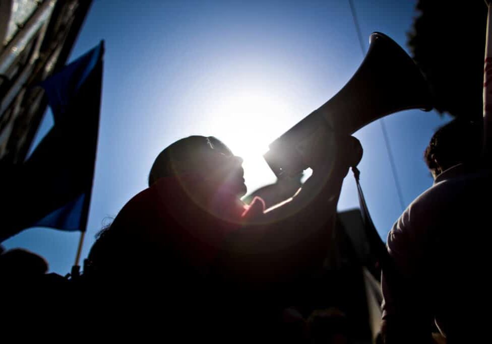 A worker uses a loudspeaker as he protests with thousands counterparts against government austerity measures during demonstrations launched by Portugal's biggest trade union called Portuguese General Workers Confederation (CGTP), in Lisbon, on July 8, 2010. AFP PHOTO/ PATRICIA DE MELO MOREIRA (Photo credit should read PATRICIA DE MELO MOREIRA/AFP/Getty Images)